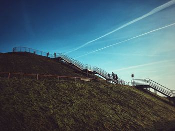 Low angle view of landscape against blue sky