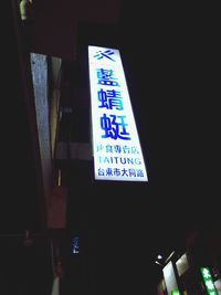 Low angle view of information sign at night