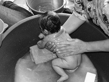 Midsection of mother bathing baby boy