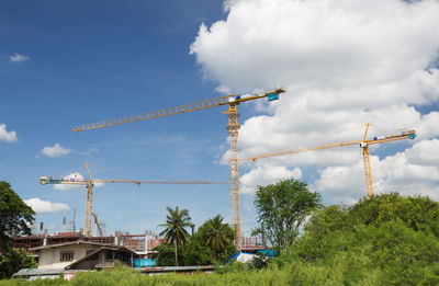 Low angle view of crane at construction site against sky