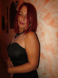 Portrait of young woman standing against wall