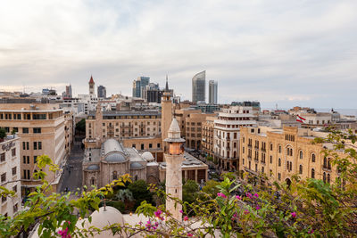 Buildings in city against cloudy sky