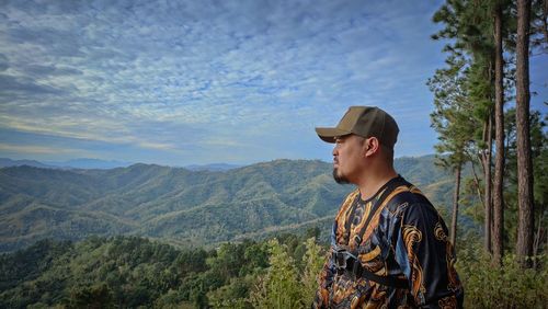 Side view of man standing against mountain