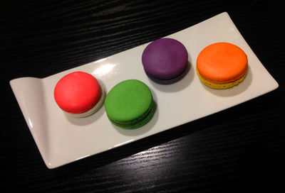 High angle view of multi colored macaroon in tray on table