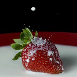 Close-up of strawberry on table against black background