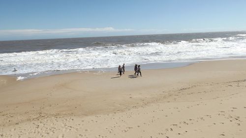 People on beach against sky