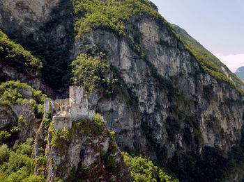 Low angle view of cliff against mountain