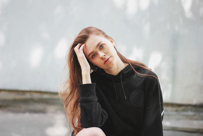 Portrait of beautiful young woman sitting outdoors