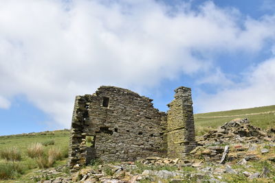 Low angle view of old ruin on field