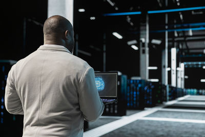 Rear view of man standing in subway