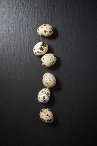 Quail eggs on a black table.