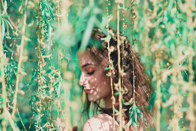 Portrait of young woman looking at plants