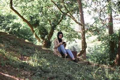 Young couple sitting on land in forest