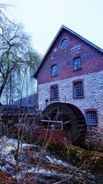 Abandoned building against sky during winter