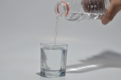 Midsection of person pouring water in glass