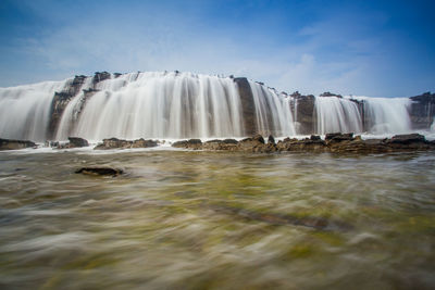 Low angle view of waterfall against sky