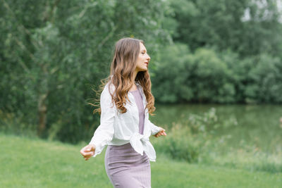 A happy woman in nature. portrait of a beautiful girl in close-up on the background of the lake