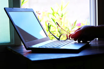 Midsection of person using mobile phone on table