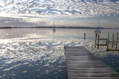 Pier on lake against sky during winter