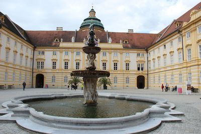 Fountain by melk abbey against sky