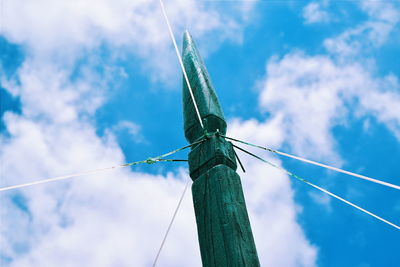 Low angle view of wooden pole against blue sky