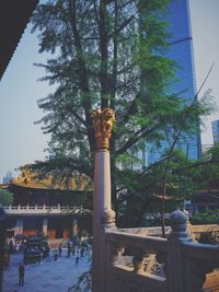 Statue in city against sky