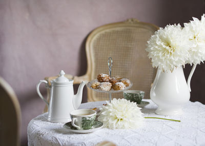 Tea break in english style, vintage retro still life, homemade buns and a bouquet of white dalias