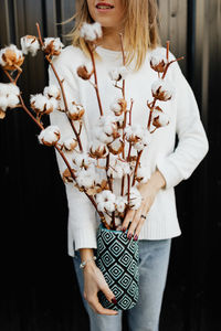 Midsection of woman holding flower vase