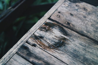 High angle view of rusty container on wooden plank