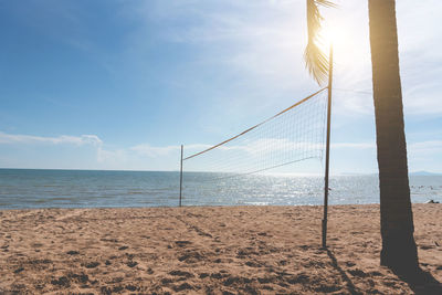 Volleyball net at beach against blue sky