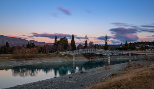 Bridge over river against sky during sunset