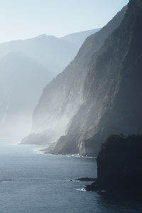 Scenic view of sea and mountains against sky