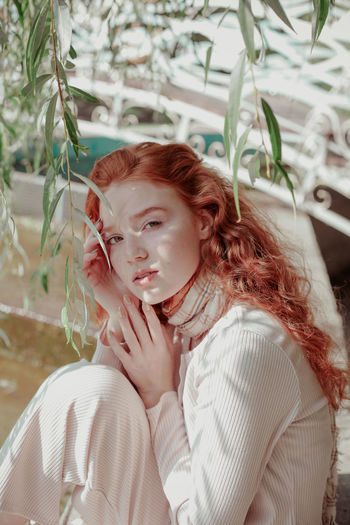 Portrait of cute teenage girl sitting outdoors