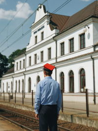 Rear view of man standing on railroad track