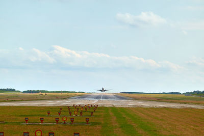 Airplane taking off from runway against sky