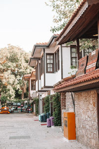 Houses by street in town against sky