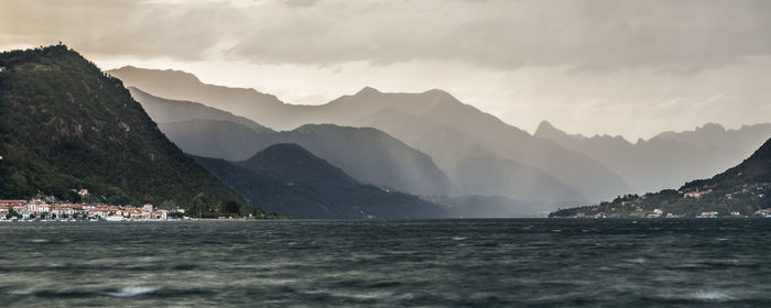 Scenic view of sea and mountains against sky