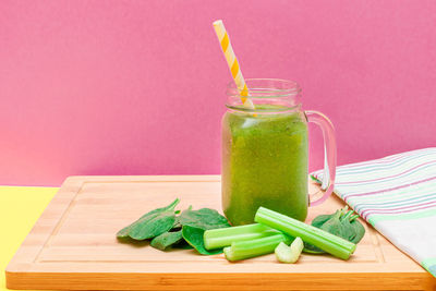 Green chili pepper on table against colored background