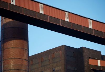 Low angle view of industrial bridge against sky