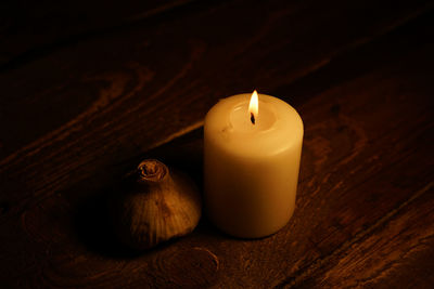 Close-up of onion and candle on table