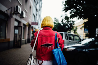 Rear view of woman with umbrella on street