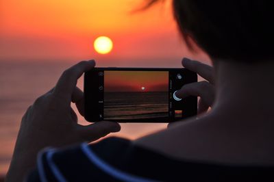 Person taking sunset shot on mobile