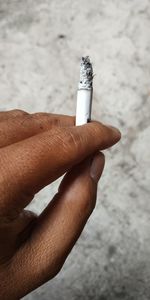 Cropped hand holding cigarette