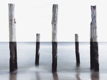 Wooden post on seashore at beach
