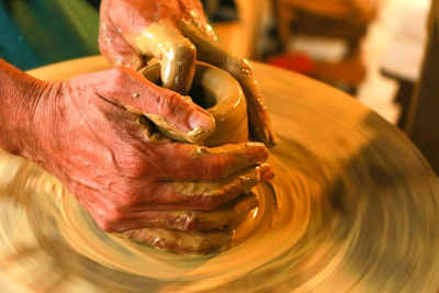 Cropped hand of man making clay