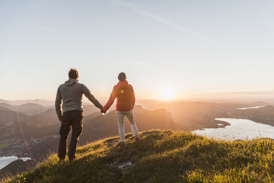 Austria, salzkammergut, couple standing on mountain summit, enjoying the view