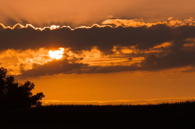 Scenic view of silhouette landscape against orange sky