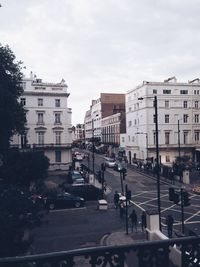 Cars on road against sky in city