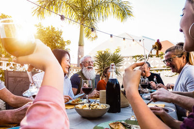 Family having food and drink against sky in yard