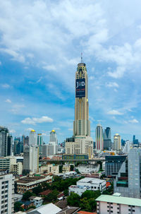 View of cityscape against cloudy sky